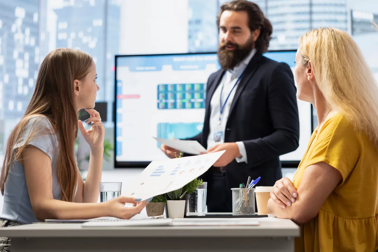 A consultant reviewing a process model with a client team at a whiteboard
